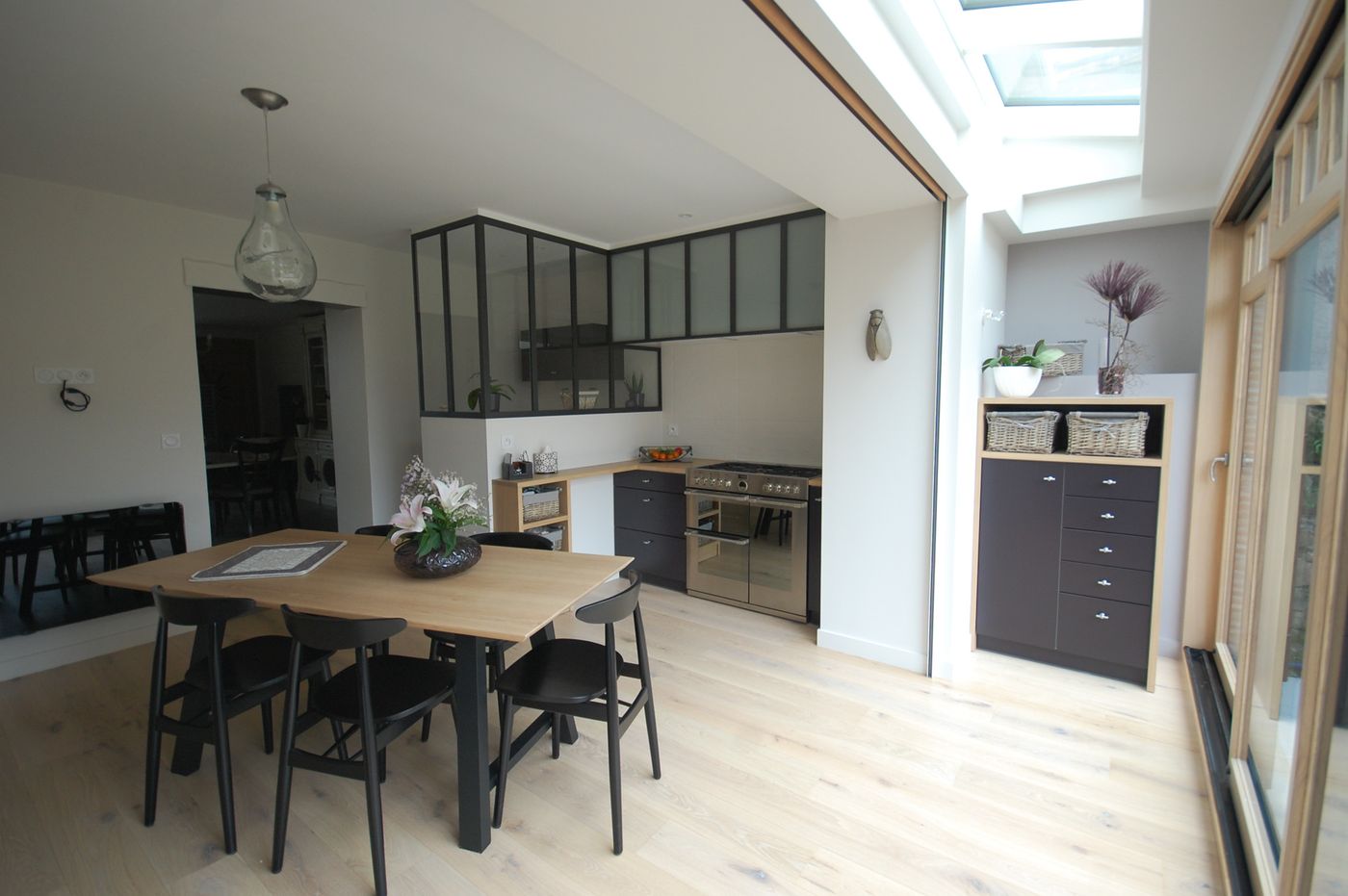 Cuisine ouverte avec verrière métallique et grande table en bois