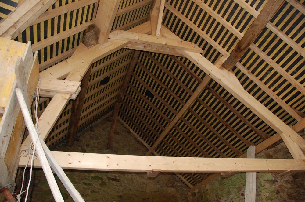 Charpente traditionnelle en cours de montage sous une toiture ancienne