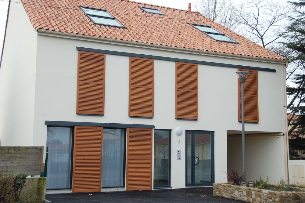 Façade blanche équipée de menuiseries et de volets coulissants en bois