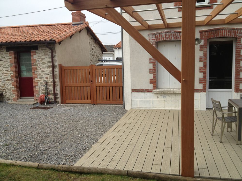 Terrasse en lames de bois abritée par une pergola à structure bois